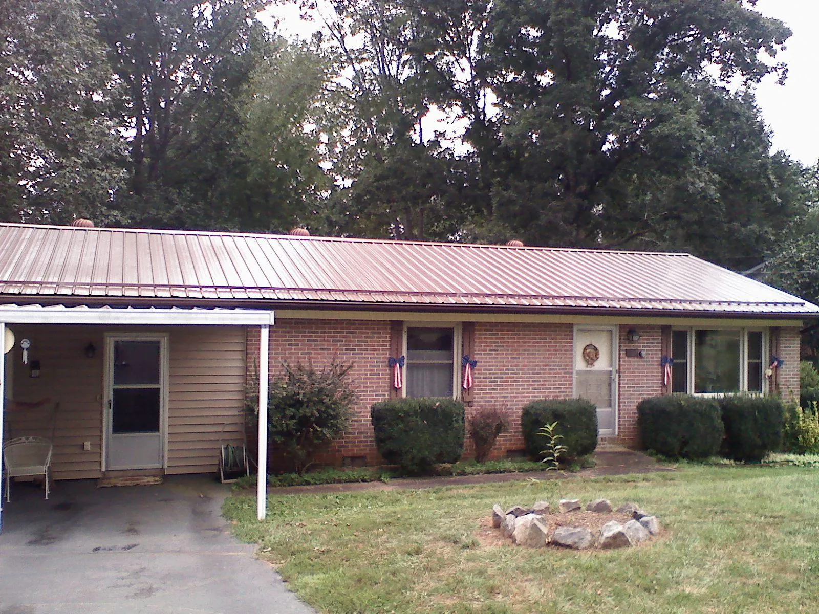 Bronze metal roof and carport on a brick ranch home — Roof Repair work by our crew in Imlay