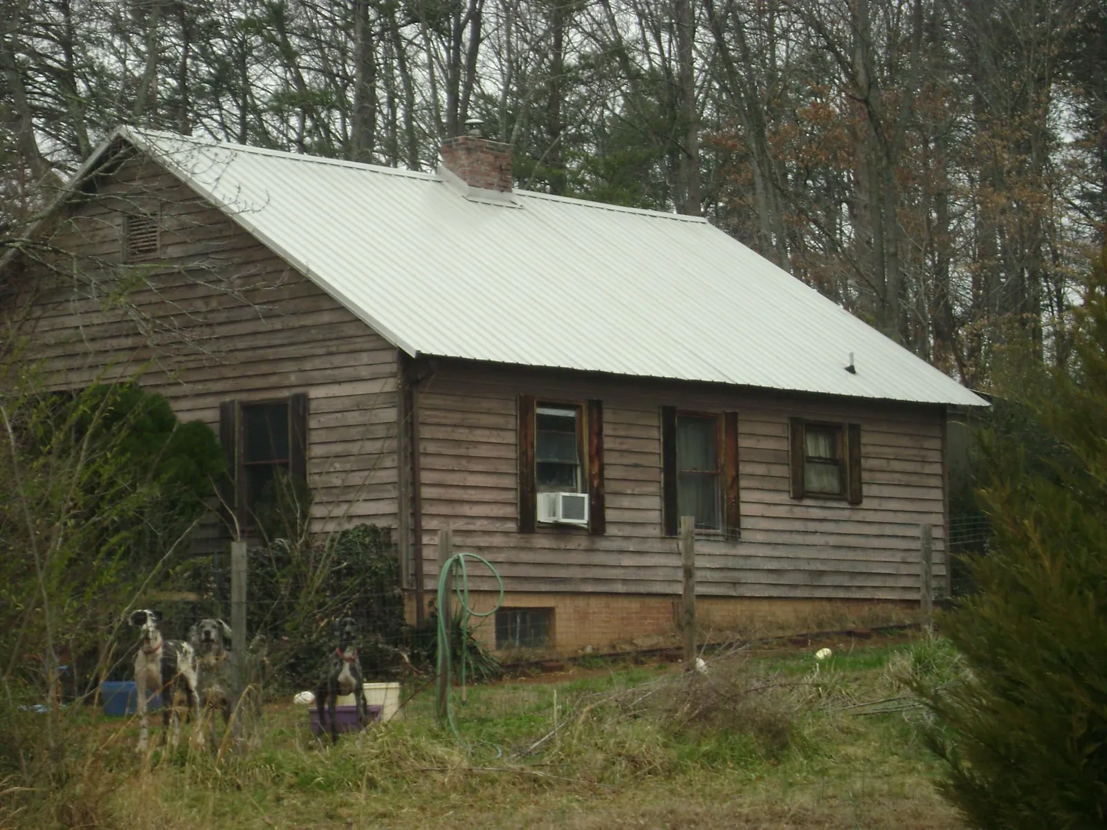 White metal roof on an old wood sided farmhouse, from a Metal Roof Installation job in Imlay